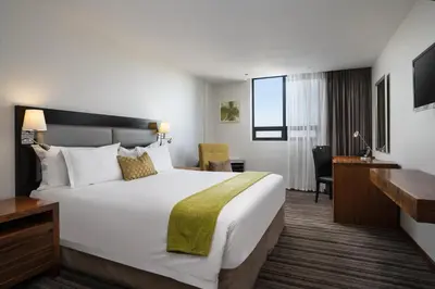 a hotel room with a large bed and a desk at Premier Hotel Midrand in Midrand