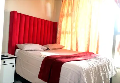 a bedroom with a red headboard and a bed at Montana Guest House in Pretoria