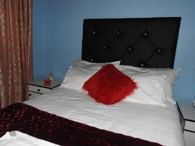 a red pillow sitting on top of a bed at Montana Guest House in Pretoria