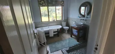 a white bathroom with a sink and a toilet at Riverside Farm in Witbank
