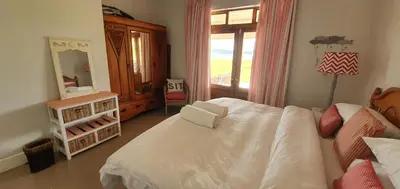 a bedroom with a white bed and a mirror at Riverside Farm in Witbank