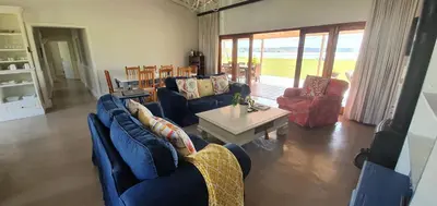 a living room with blue couches and a table at Riverside Farm in Witbank