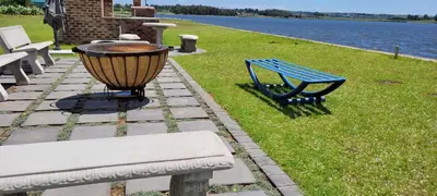 a blue bench and a light next to a body of water at Riverside Farm in Witbank