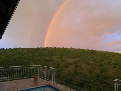 a rainbow from the deck of a house at Elements Bush Lodge in Moheme
