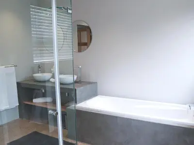 a bathroom with two sinks and a bath tub at Elements Bush Lodge in Moheme