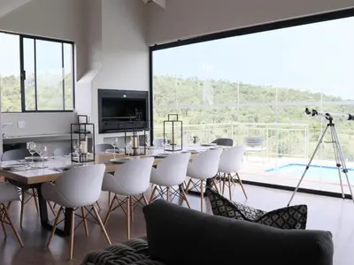 a dining room with a table and chairs and a camera at Elements Bush Lodge in Moheme
