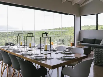 a dining room with a large table and chairs at Elements Bush Lodge in Moheme