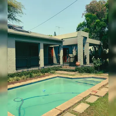 a house with a swimming pool in front of a house at Muckleneuk Guest House in Pretoria