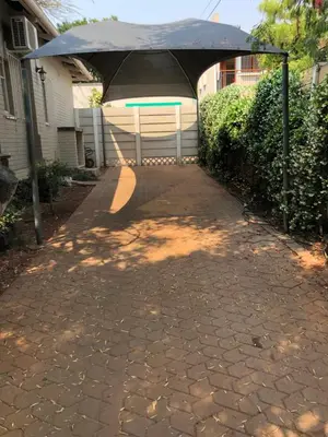 an umbrella over a walkway in a driveway at Muckleneuk Guest House in Pretoria