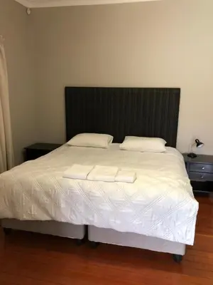 a bedroom with a bed with two pillows on it at Muckleneuk Guest House in Pretoria