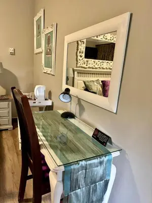 a dining room with a glass table and a mirror at Muckleneuk Guest House in Pretoria