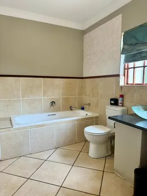 a bathroom with a tub and a toilet and a sink at Muckleneuk Guest House in Pretoria