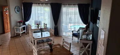 a living room with a large window with curtains at Christa's Place 897 in Pretoria