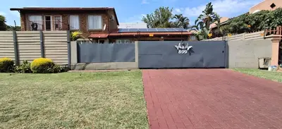 a house with a blue fence and a brick driveway at Christa's Place 897 in Pretoria