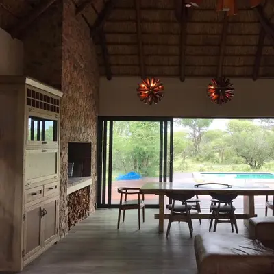 a kitchen and dining room with a table and chairs at Duiker lodge in Mmukubyane