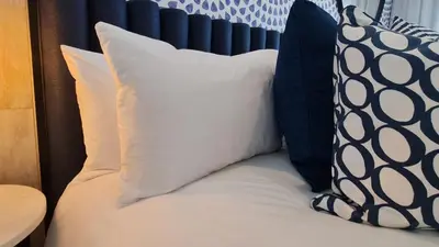 a bed with blue and white pillows on it at MINT Resorts The Blyde in Pretoria