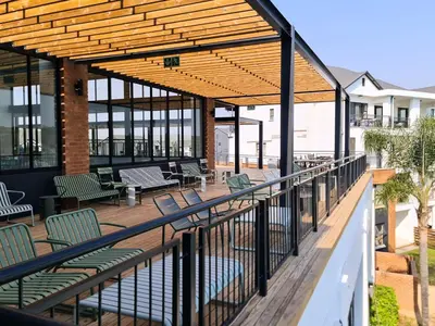 a deck with chairs and tables on a building at MINT Resorts The Blyde in Pretoria