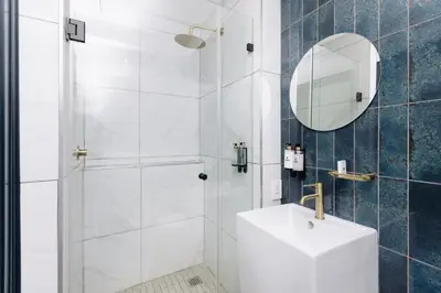 a bathroom with a shower with a sink and a mirror at MINT Resorts The Blyde in Pretoria