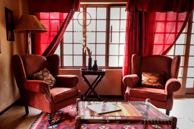 a living room with two chairs and a coffee table at Khaya Umdani Guest Houses in Marloth Park