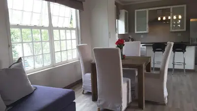 a kitchen and dining room with a table and chairs at Versailles in Pretoria