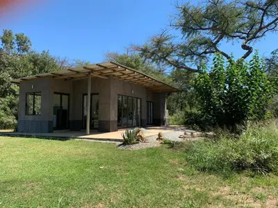 a small house in a field with a yard at Crocodile Sands River Lodge in Nelspruit