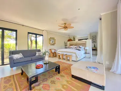 a living room with a bed and a couch at Crocodile Sands River Lodge in Nelspruit