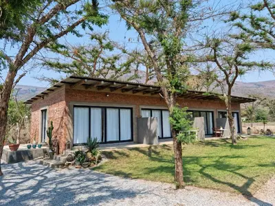 a brick house with trees in front of it at Crocodile Sands River Lodge in Nelspruit