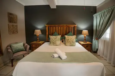 a bedroom with a bed with two towels on it at Ivory Tusk Lodge in Tzaneen