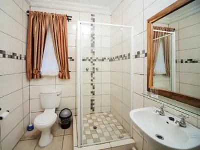 a bathroom with a toilet and a sink at Ivory Tusk Lodge in Tzaneen