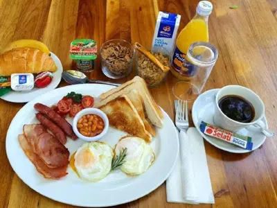 a plate of breakfast food with eggs bacon toast and coffee at Ivory Tusk Lodge in Tzaneen
