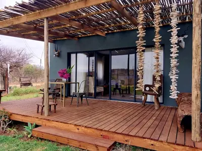 a wooden deck with a pergola at hippomoon lodge game reserve in Hoedspruit