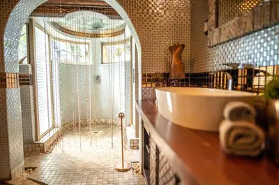 a bathroom with a tub and a shower with a sink at hippomoon lodge game reserve in Hoedspruit
