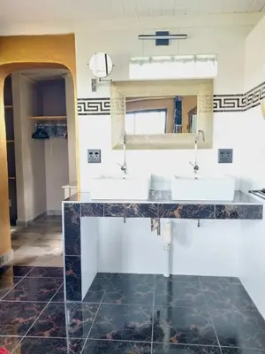 a bathroom with two sinks and a mirror at hippomoon lodge game reserve in Hoedspruit