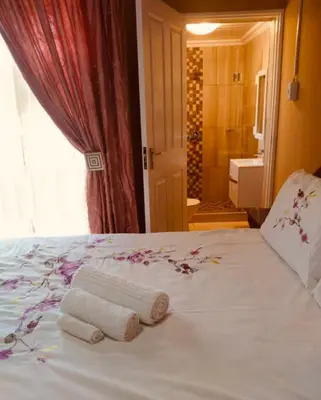 a bedroom with a white bed with towels on it at Erins Haven - Polokwane in Polokwane