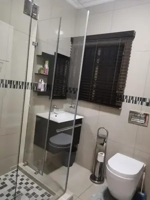 a bathroom with a shower and a toilet and a sink at Erins Haven - Polokwane in Polokwane