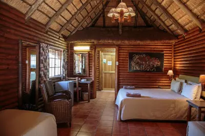 a bedroom with a bed and a desk in a room at Kwalata Game Lodge in Klipdrift