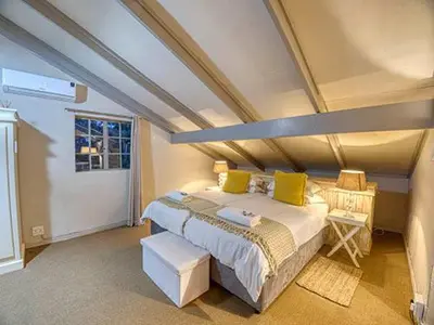 a bedroom with a large bed with yellow pillows at Kruger park House in Hazyview
