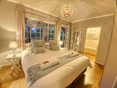 a bedroom with a large bed and a window at Kruger park House in Hazyview