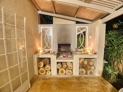 a kitchen with a stove in a room with logs at Kruger park House in Hazyview