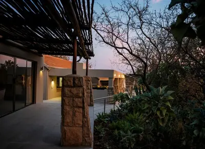a house with a stone pillar in a yard at Elements Private Golf Villa 295 in Mabula