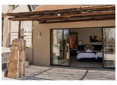 a bedroom in a house with sliding glass doors at Elements Private Golf Villa 295 in Mabula