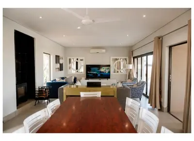 a living room with a dining room table and a couch at Elements Private Golf Villa 295 in Mabula