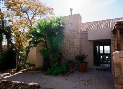 a house with two palm trees in front of it at Elements Private Golf Villa 295 in Mabula