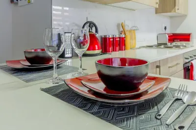 a kitchen counter with two bowls and wine glasses at Buckingham Palace 2 Bed 2 Bath in Midrand