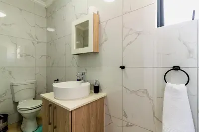 a bathroom with a sink and a toilet at Buckingham Palace 2 Bed 2 Bath in Midrand