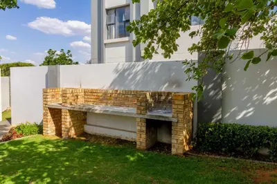 a brick fireplace in a yard next to a building at Buckingham Palace 2 Bed 2 Bath in Midrand