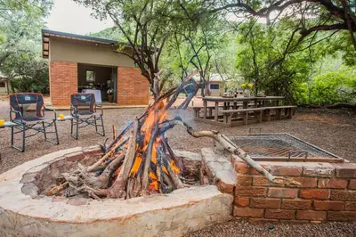 a fire pit in front of a house at Zwartkloof Adventures Tented Camp in Bela-Bela