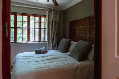 a bedroom with a bed with a stuffed animal on it at GILLFORD GALLERY ACCOMMODATION in Benoni