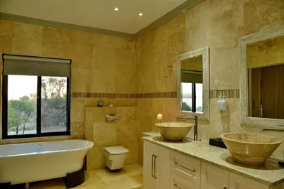 a bathroom with two sinks and a tub and a toilet at Kameeldrift Waterfront Estate & Resort in Brits