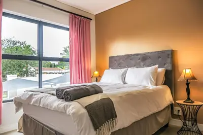 a bedroom with a large bed with a large window at Insaka 1 The Blyde Crystal Lagoon Experience in Pretoria